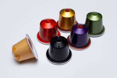 Folyoyla mühürlenmiş renkli kahve kapsülleri. Beyaz arka planda izole edilmiş. Kahve makinesi konsepti  