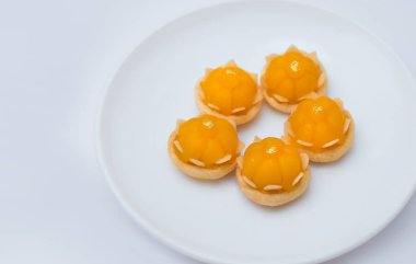 Kanom Ju Kut beyaz tabakta servis yapıyor. Tacı andıran sarı bir tatlı. Çoğunlukla yumurta sarısı ve şekerden yapılmış. Geleneksel Tayland Tatlısı