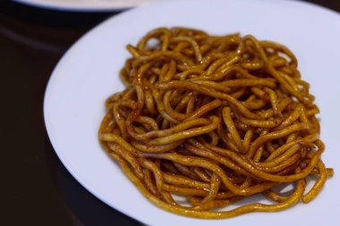 Zengin, koyu soya sosuyla kaplanmış kalın, çiğnenmiş Şangay Kızarmış Eriştesi. Bu basit, iştah açıcı görüntü Çin mutfağının klasik bir tarzını temsil ediyor.