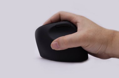 Beyaz arka planda siyah ergonomik bir fareyi kavrayan bir insan elinin yan görüntüsü, bilek gerilmesini azaltmak ve duruşunu iyileştirmek için tasarlandı.