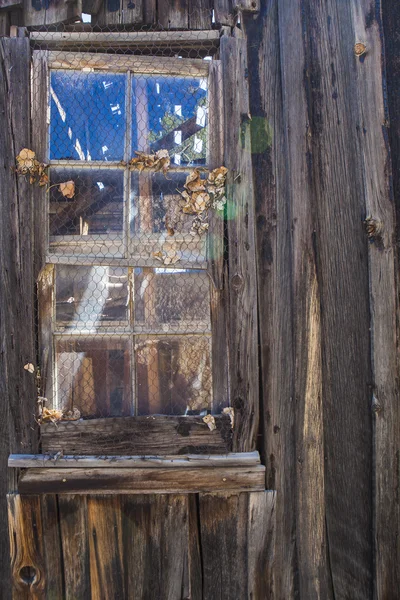 Okno ve staré chatrči — Stock fotografie