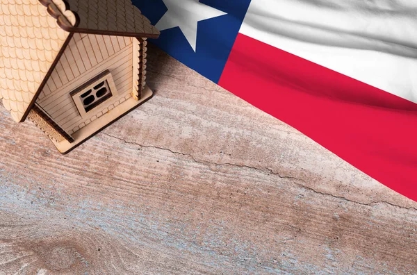 House model near Texas flag. Real estate sale and purchase concept. Space for text.