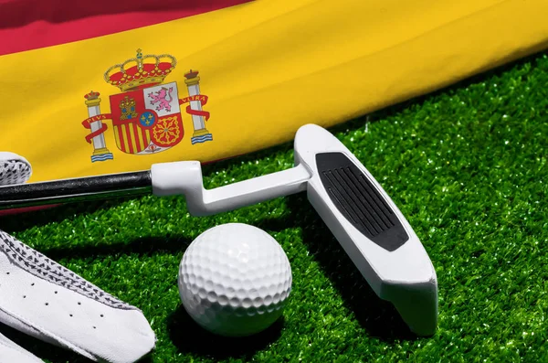 Golf ball and club with flag of Spain on green grass. Golf championship in Spain