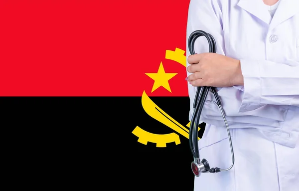 Female doctor with stethoscope in hand on the background of the Angola flag. Concept medicine, pandemic in the country