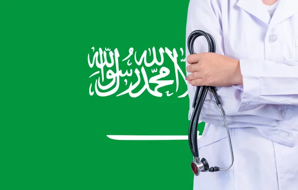 Female doctor with stethoscope in hand on the background of the Saudi Arabia flag. Concept medicine, pandemic in the country