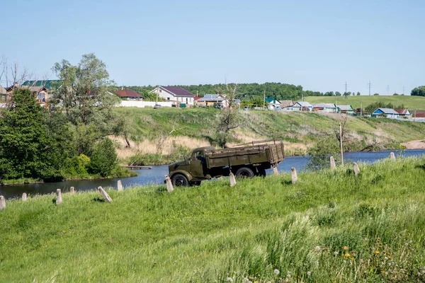 old front-line truck on the river Bank in the village