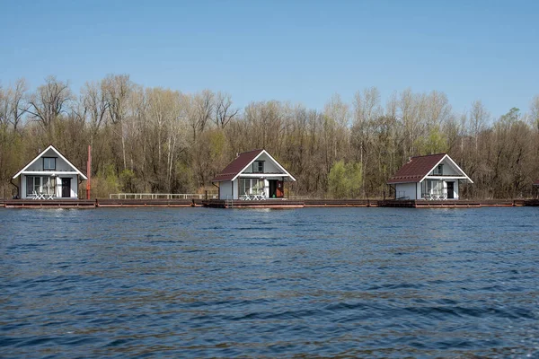 Baharda nehirde tahta yüzen yüzen evler. Nehirdeki mini otel.