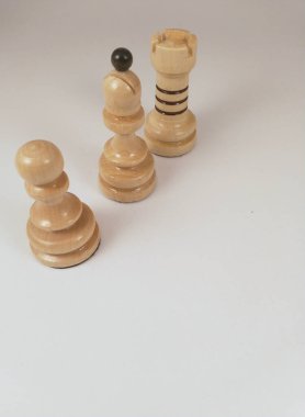 Beyaz arkaplanda tahta satranç taşları.