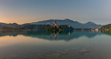 Bled Gölü 'nün panorama resmi, Bled Gölü' nün merkezinde, gün batımında, kenardan çekildi..