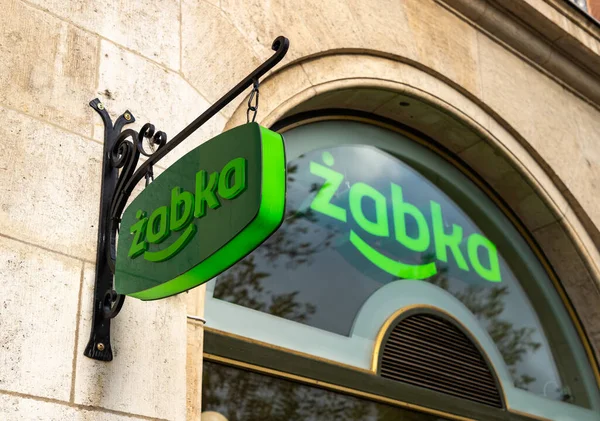 Dükkanlardan birinin önünde sergilenen Zabka logosunun resmi..