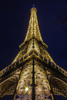 Geceleri aydınlanan Eyfel Kulesi 'nin bir resmi..