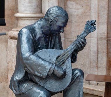 Portekiz 'in geleneksel Fado müzik türünü temsil eden Portekizli bir gitaristi gösteren bir heykel.).