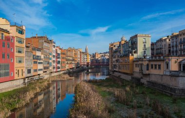 Girona 'nın Onyar nehrinin ve bitişik renkli binalarının bir resmi.