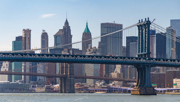A picture of the Manhattan Bridge overlooked by the skyscrapers of Lower Manhattan.