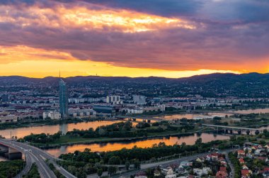 Güneşin Viyana ve Tuna nehrinin banliyölerinde batışının bir resmi..
