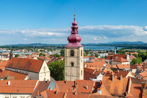 Ptuj Şehir Kulesi 'nin bir resmi, Aziz George Kilisesi ve Aziz Peter ve Paul Minorite Manastırı da görünür..