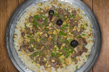 Pirinç ve deve eti geleneksel Arap yemekleri ana yemek restoran öğle yemeği badem ve çam tohumlarıyla servis edilir.. 