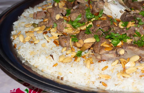 camel meat with rice traditional Arab food main course restaurant lunch served with almonds and pine seeds.