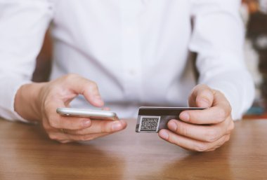 kredi kartı ve akıllı telefon tutan kadın