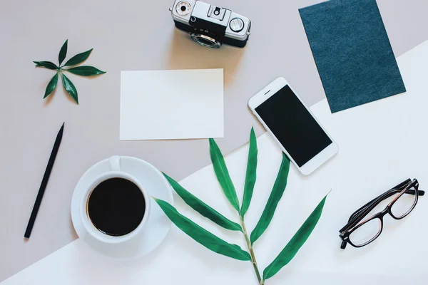 Mesa de trabalho com smartphone, café, câmera — Fotografia de Stock