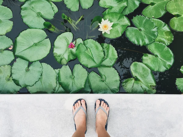 Vrouwelijke voeten in sandalen op de stoep — Stockfoto