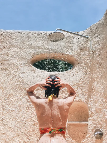 Giovane donna in costume da bagno in doccia — Foto Stock