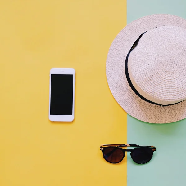 Téléphone intelligent avec chapeau panama et lunettes de soleil — Photo