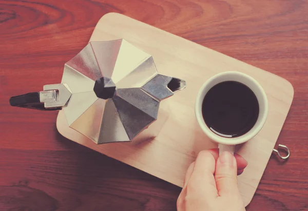 Hand holding coffee cup and moka pot — Stock Photo, Image