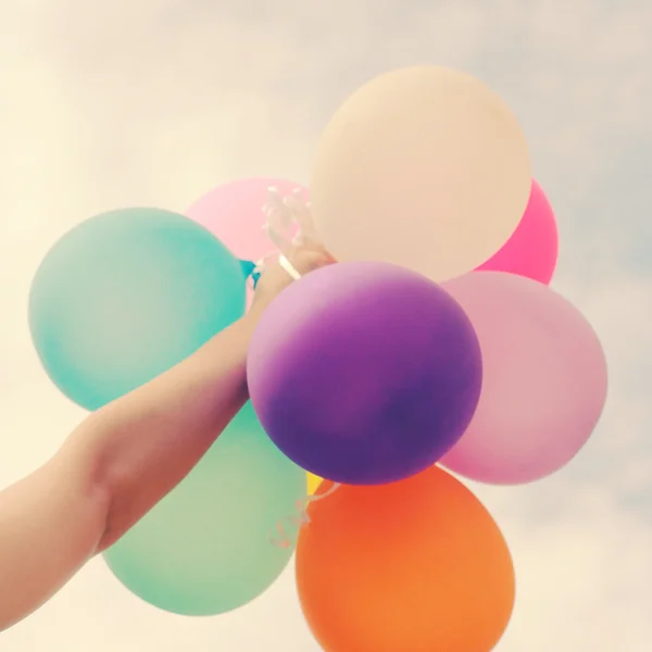 Mano sosteniendo globos multicolores —  Fotos de Stock