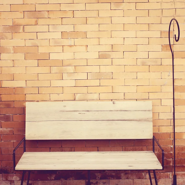 Дерев'яний стілець на цегляній стіні — стокове фото