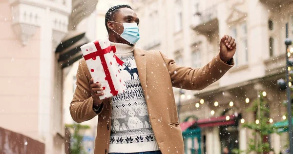 Feliz Hombre Afroamericano Guapo Bailando Ciudad Nevada Con Caja Regalo —  Fotos de Stock