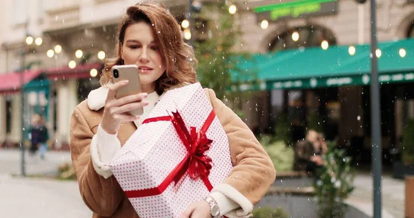 Detailní Portrét Šťastné Bělošky Vyzdobeném Městě Vánoční Dárek Smskování Smartphone — Stock fotografie