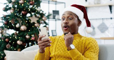 Noel arifesinde Afrikalı Amerikalı neşeli sürpriz adam piyango kazanma zaferiyle ilgili cep telefonundan harika haberler aldı. İnanılmaz şans, yeni yıl mucizesi, samimi duygular, Xmas indirimi