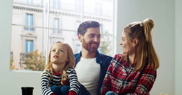 Close-up van liefdevolle familie moeder en vader spreken met weinig leuke kleuterschool meisje kiezen decor van nieuwe kinderkamer tijdens renovatie en verbetering van het huis. Ouders en mooi kind praten over design — Stockfoto