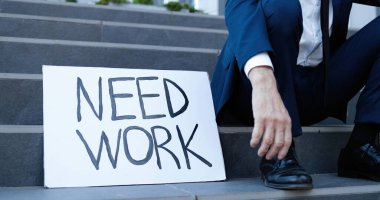 Gözlüklü, kravatlı, üzgün, yaşlı beyaz bir adam dışarıda, masada oturuyor ve iş arıyor. Emekli yaşlı, kır saçlı, üzgün bir erkek kovuldu. Büyükbaba kriz anında iş yeri arıyor..