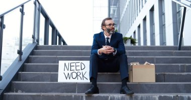 Beyaz, orta yaşlı, gözlüklü, kravatlı, dışarıda oturan üzgün bir adam. Çalışmam lazım. İş arıyorum. Emekli son sınıf öğrencisi, üzgün bir erkek. İş adamı kriz anında işini ve iş yerini kaybetti.