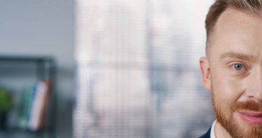 Sakallı, yakışıklı, genç, kızıl saçlı erkek işçilerin kameraya bakıp mutlu bir şekilde gülümsemelerini yakından çek. Yüzünde gülümseme olan neşeli bir adamın yarım yüzü. İş adamı, olumlu duygular