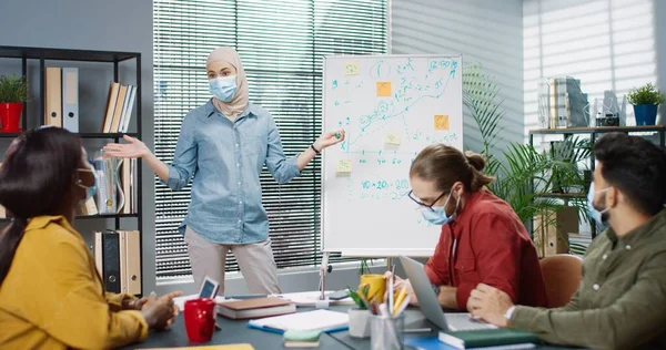 Joven feliz equipo multiétnico de profesionales sentados en el gabinete en la discusión del proyecto hablando de la estrategia de desarrollo de la empresa con los trabajadores, reunión de negocios, trabajo en concepto de cuarentena — Foto de Stock