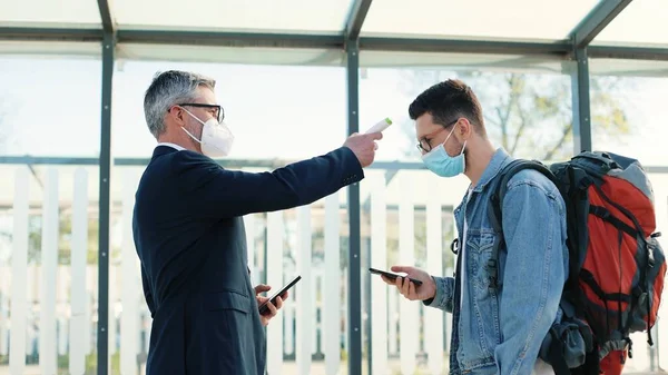 Sidovy Kaukasiska Manliga Flygplatsarbetare Kontrollera Hälsa Och Mäta Temperaturen Hos — Stockfoto