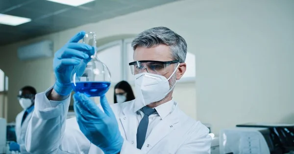 코카서스에서 경험이 화학자를 가까이 파란색 액체가 들어간 제품을 코트를 바이러스 — 스톡 사진