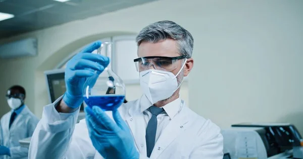 코카서스에서 경험이 화학자를 가까이 파란색 액체가 들어간 제품을 코트를 바이러스 — 스톡 사진