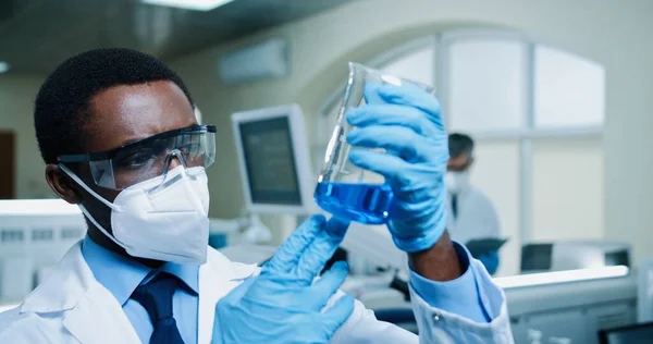 Закрити Аптекаря Афроамериканця Окулярах Маску Синьою Рідиною Сучасній Лабораторії Робочому — стокове фото