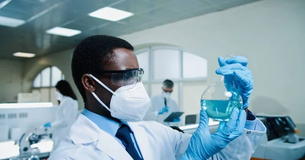 집중적으로 근무하는 아프리카 미국인젊은 연구원의 마스크를 코로나 바이러스 치료제를 개발하고 — 스톡 사진