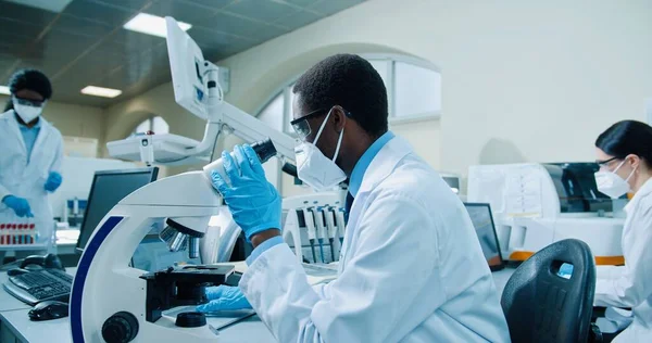 Побічний Вид Афроамериканського Вченого Медика Масці Рукавичках Який Сидить Лабораторії — стокове фото