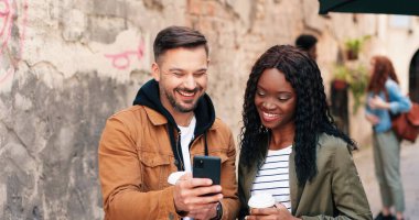 Kahvesini içen kıvırcık saçlı kadının portre görüntüsü ve en iyi arkadaşıyla tablette tartıştığı bir şey..
