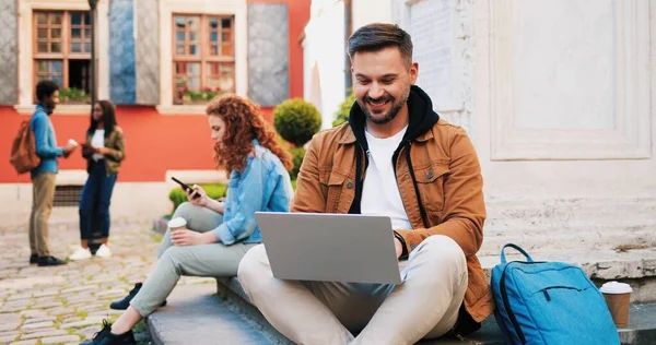 Ung Leende Brunett Man Bär Casual Kläder Med Bärbar Dator — Stockfoto