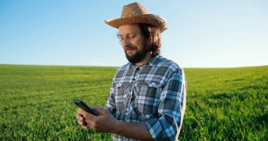 Kalite kontrollü tarım teknolojisi. İşçi akıllı telefondan hasat büyümesini izliyor. Yapay zeka tarafından veri toplama ve analiz etme. Gelecekteki tarım ürünleri konsepti