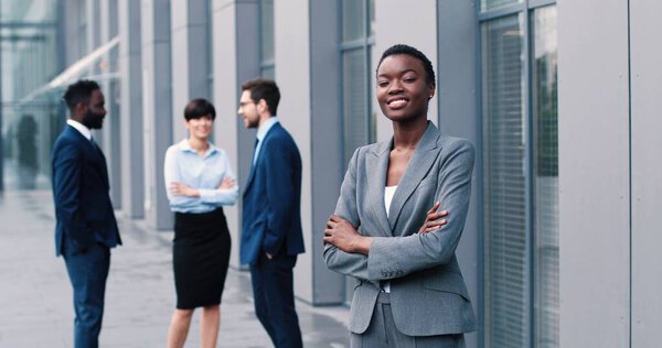 Корпоративная тайм-аут культура. Талия портрет деловой женщины, стоящей на улице рядом с ее рабочим местом и глядящей на город с удовольствием улыбкой