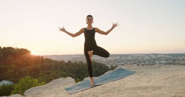 Sakin bakışlı, düşünceli, barışçıl beyaz kadın dışarıda meditasyon yaparken namaste jesti yapıyor. Doğada rahatlamaya çalışan bir kadın.