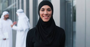 Yemek molasında başörtüsü takan mutlu iş kadınının belden yukarı portre görüntüsü ve ofis merkezine yakın gülümsemesi. İş adamları konsepti